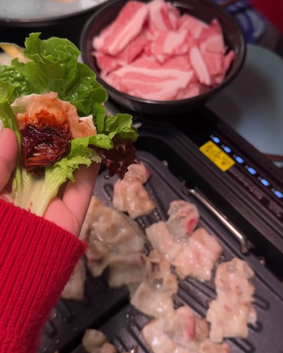 De la pâte de soja épicée appliquée sur une tranche de porc dans une feuille.