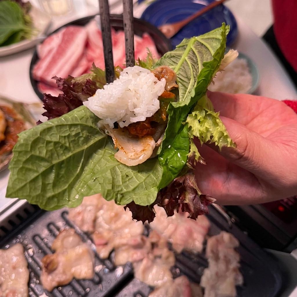 Une cuillerée de riz blanc ajoutée dans un wrap contenant déjà le porc et la sauce.