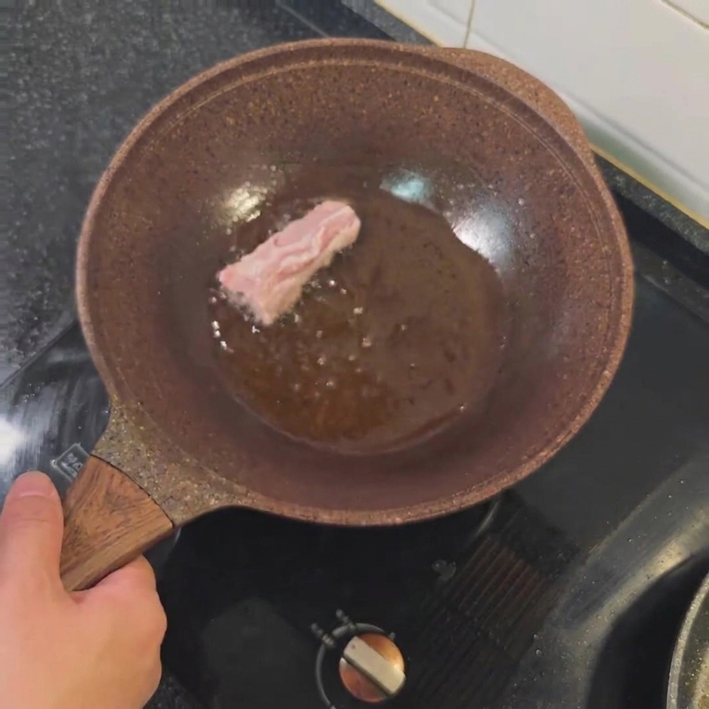 Travers de porc frits dans de lhuile chaude jusquà ce quils soient dorés.