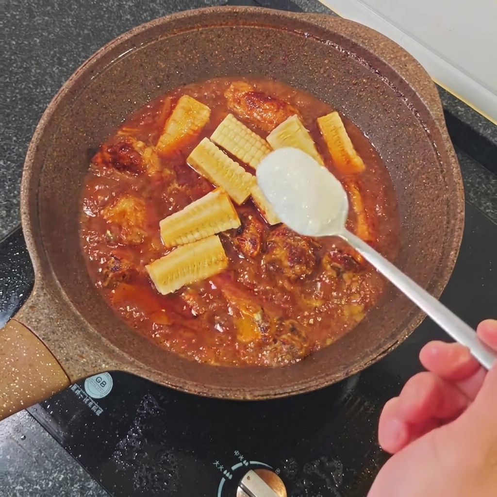 Une cuillère à soupe de sucre blanc ajoutée au liquide de braisage frémissant dans la poêle.