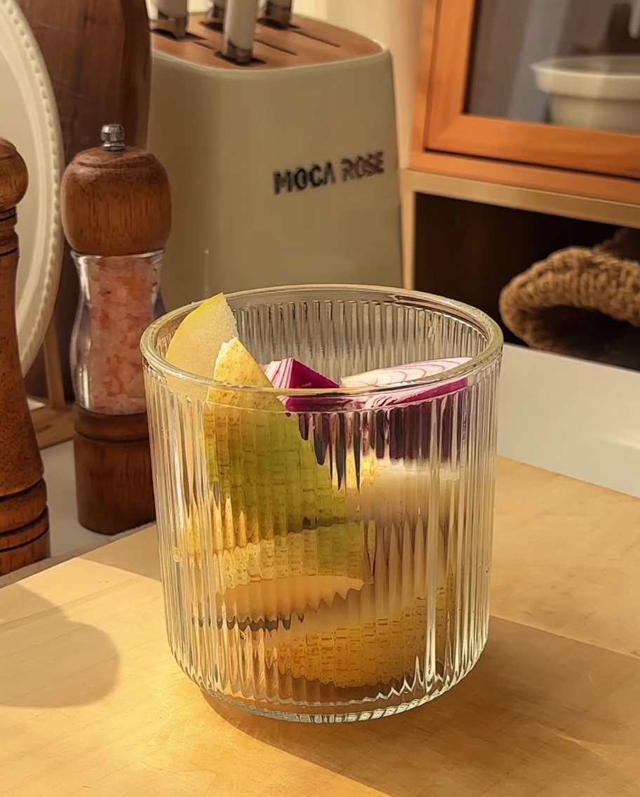 Un mixeur rempli de morceaux de pommes, poires, oignons et ail prêts à être mixés.