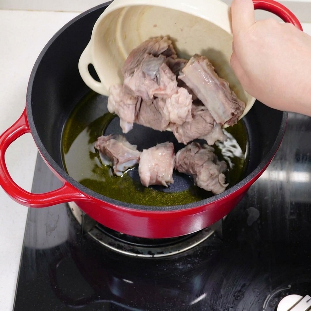 Travers de porc blanchis en train de sauter dans une marmite avec de lhuile chaude.