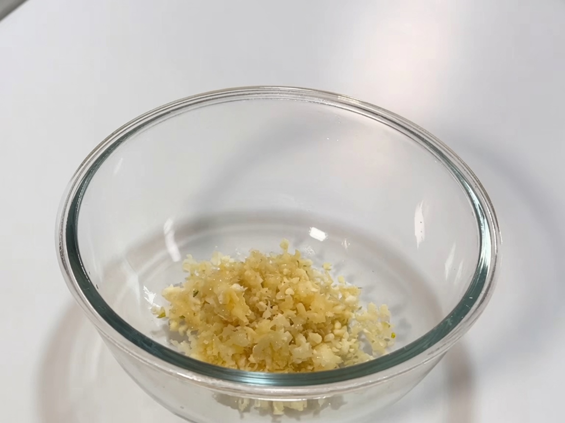 Bol en verre contenant le mélange de pâte de piment, sauce soja et aromates pour la sauce de braisage.
