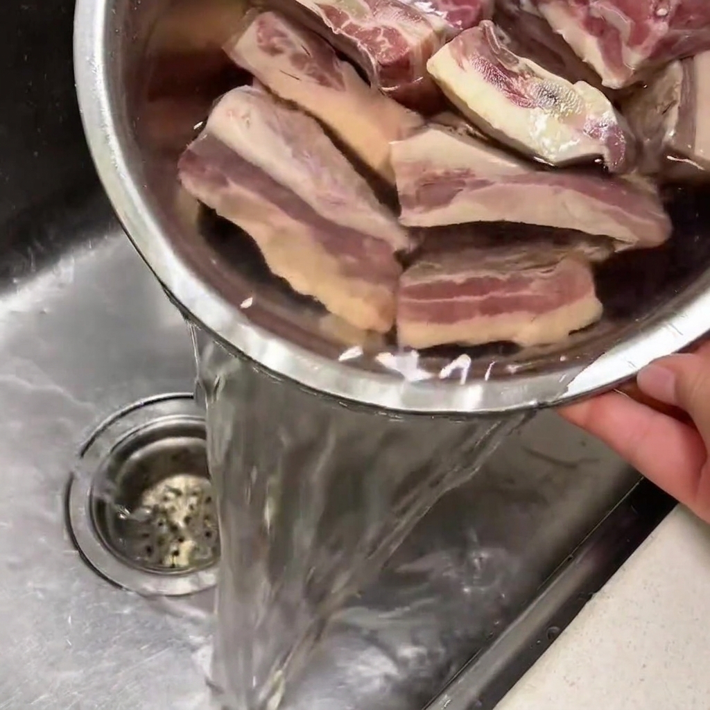 Côtes de bœuf trempant dans un bol deau froide dans un évier de cuisine.