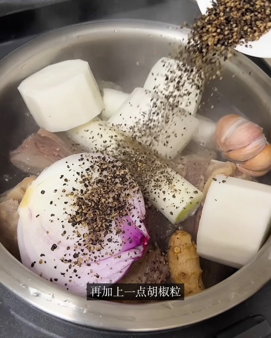 De leau chaude versée dans le cuiseur de riz sur le bœuf et les aromates.