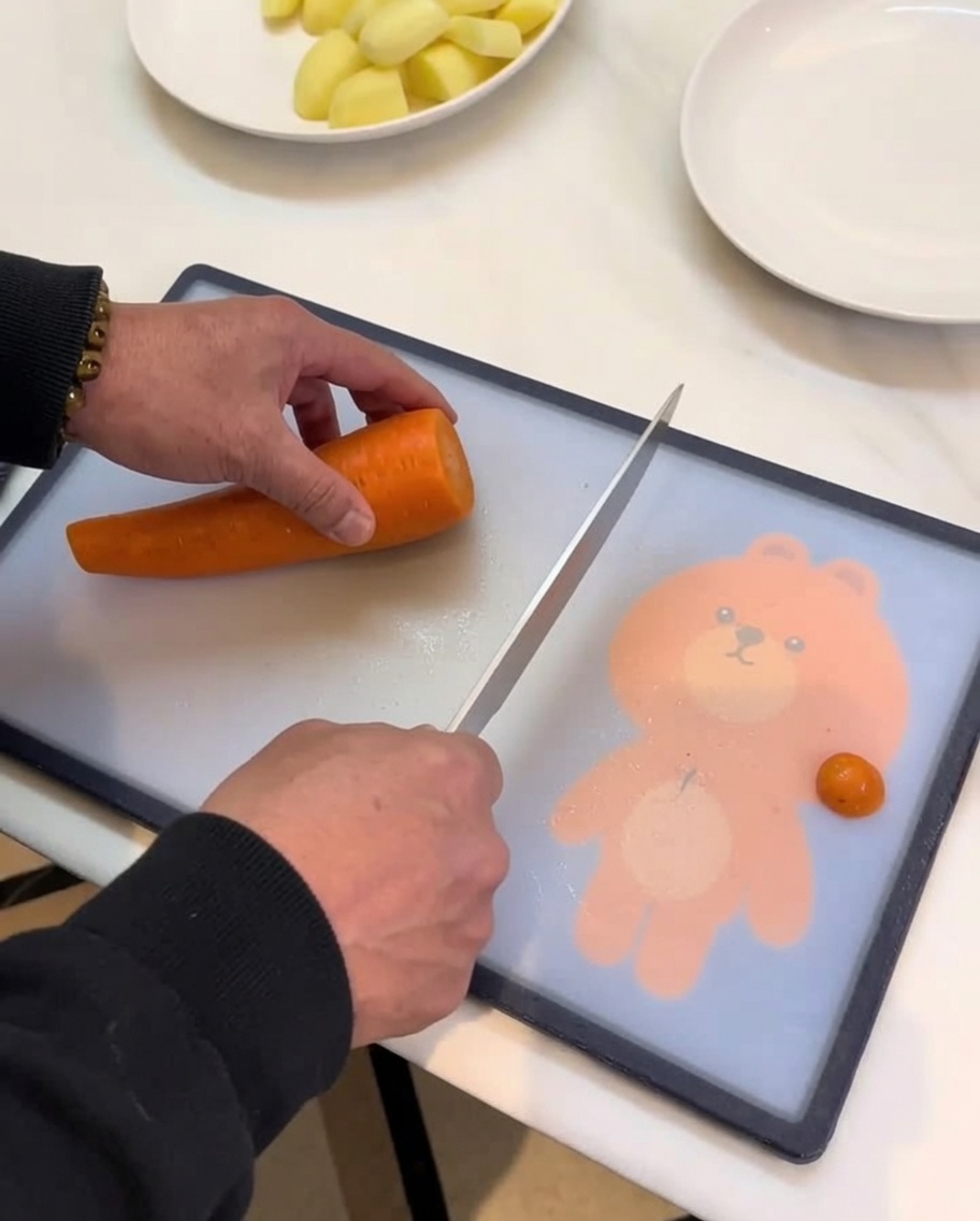 Carottes, pommes de terre et autres légumes-racines coupés en morceaux réguliers sur une plancha en bois.