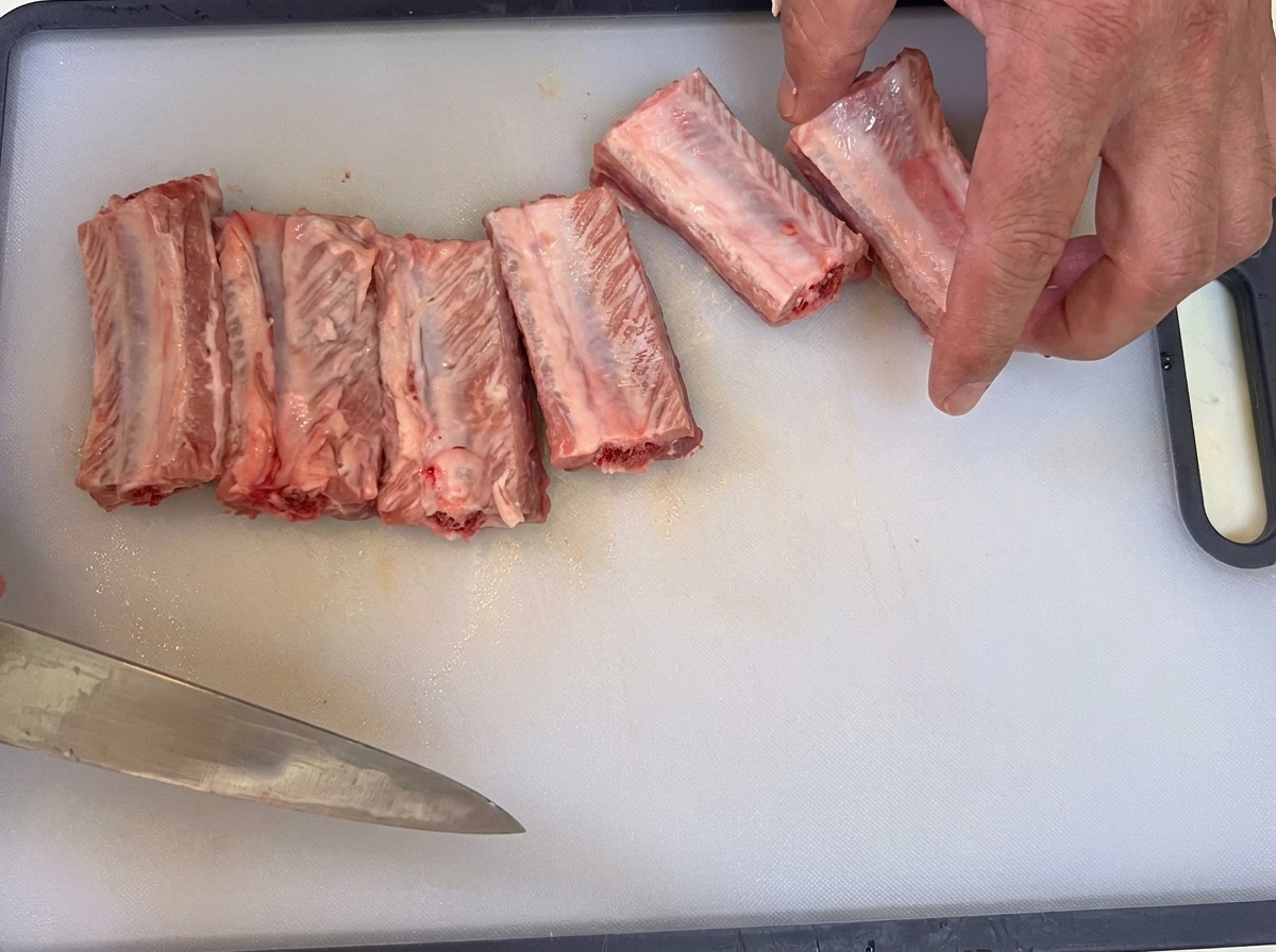 Un couteau retirant la fine membrane protectrice à larrière des côtes de porc crues.
