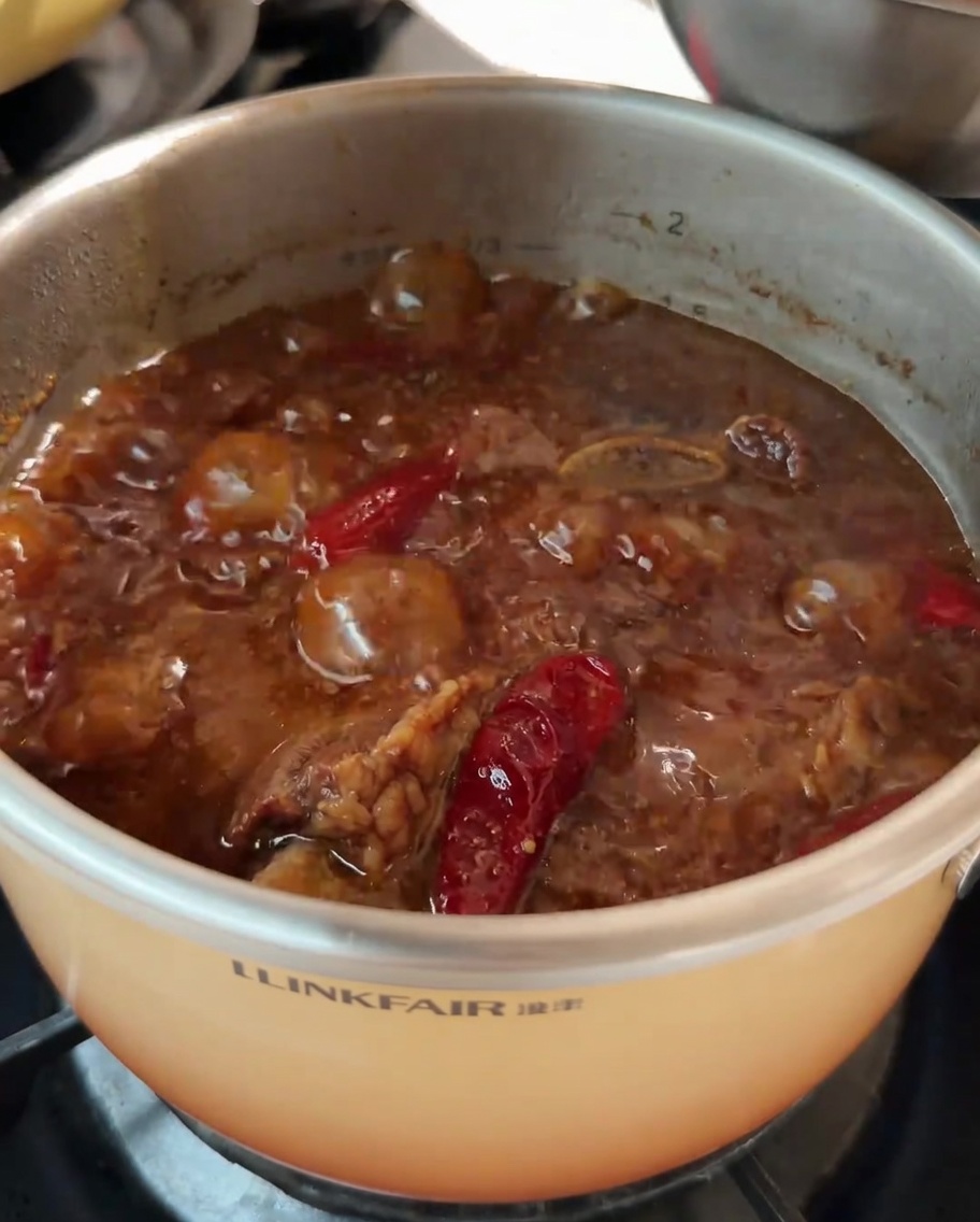 Carottes coupées ajoutées à la casserole de soupe de côtes de bœuf pendant quelle mijote.