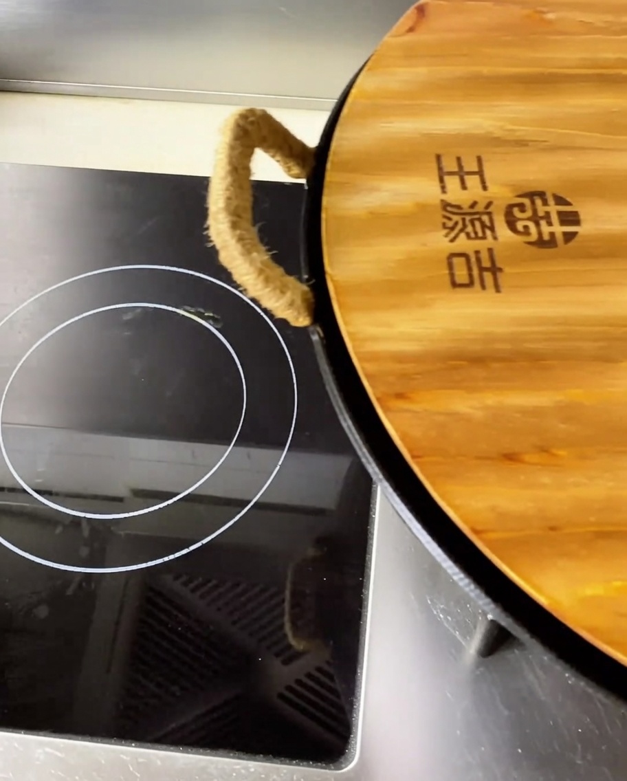 Gros plan sur des morceaux déchine de porc braisée et tendre dans un bouillon rouge parfumé à lintérieur dun grand wok.