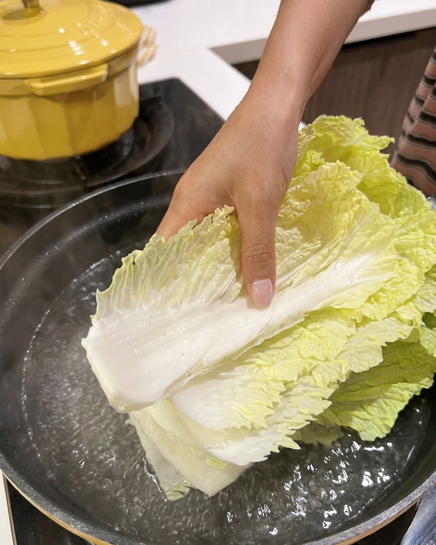 Feuilles de chou chinois frais immergées dans une casserole deau bouillante.