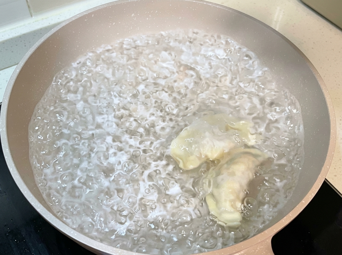 Raviolis enveloppés en train dêtre plongés dans une grande casserole deau bouillante.