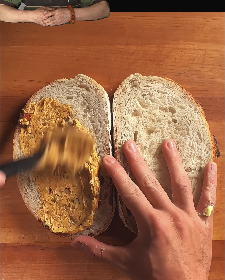Tranches de pain au levain rustique garnies dune sauce riche étalée à laide dune cuillère.