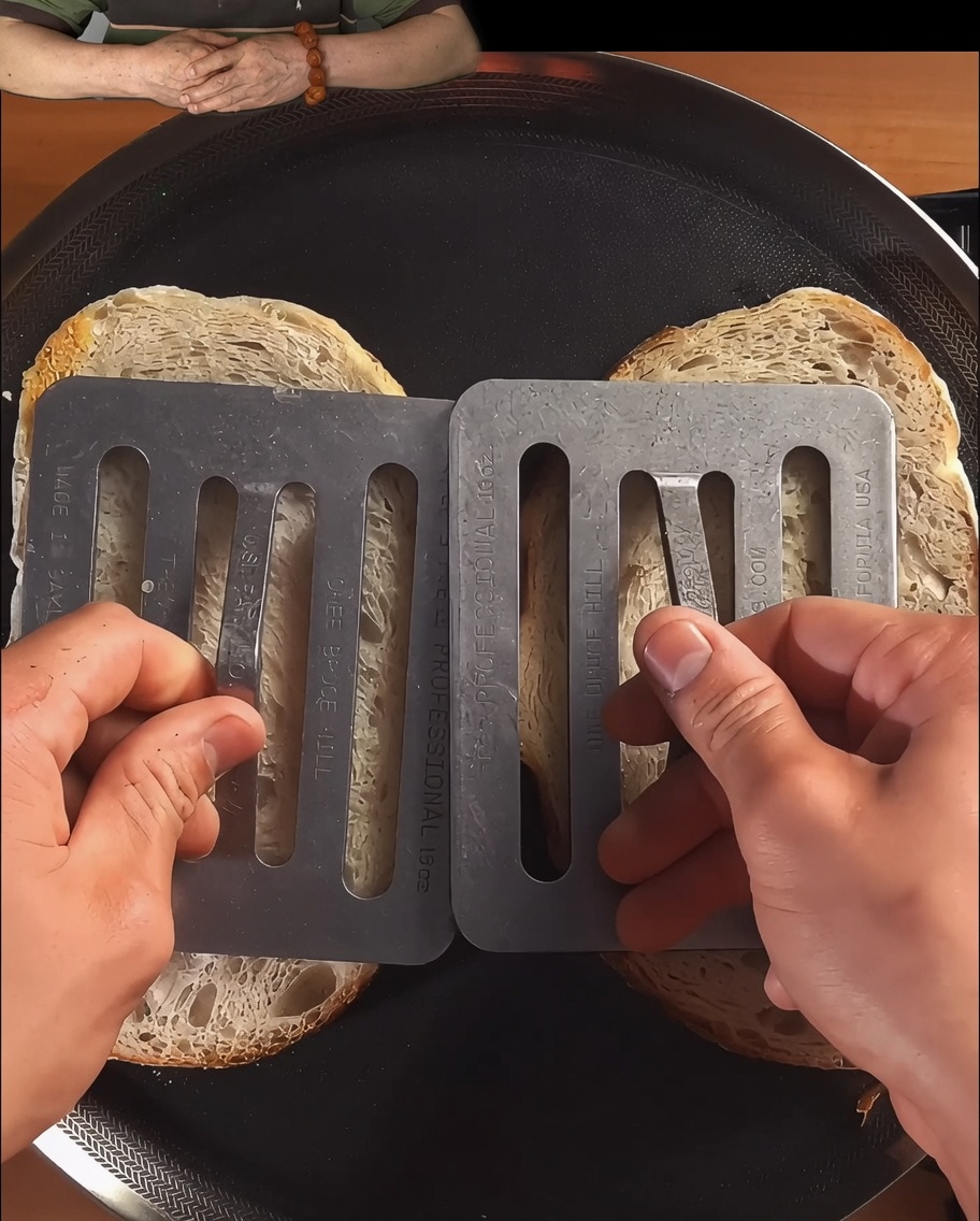 Tranches de pain pressées et toastées dans une poêle noire jusquà lobtention dune belle dorure.