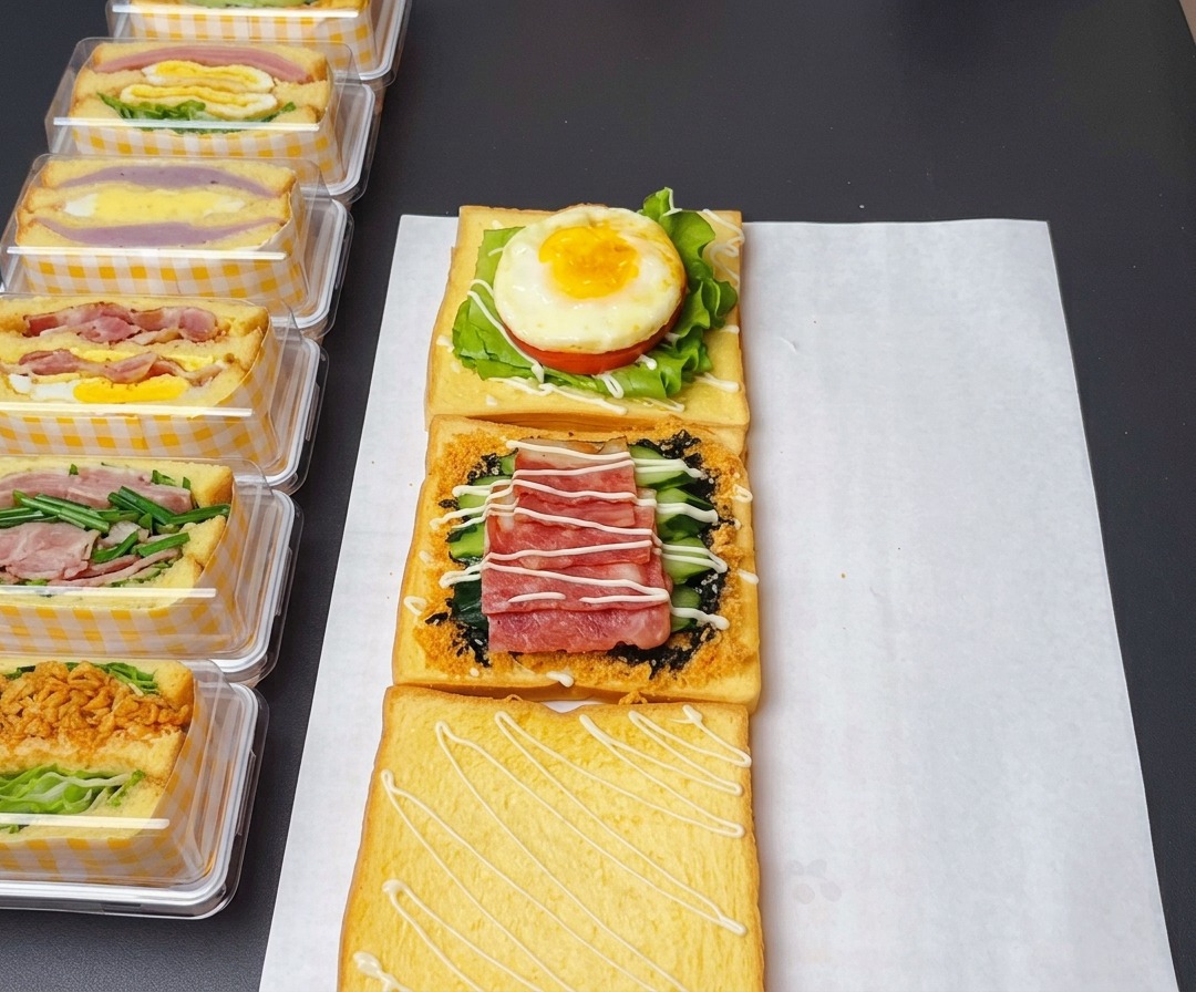 Les étages du sandwich assemblés avec de la sauce salade douce, du ketchup sur lœuf et de la sauce moutarde au miel sur le bacon.