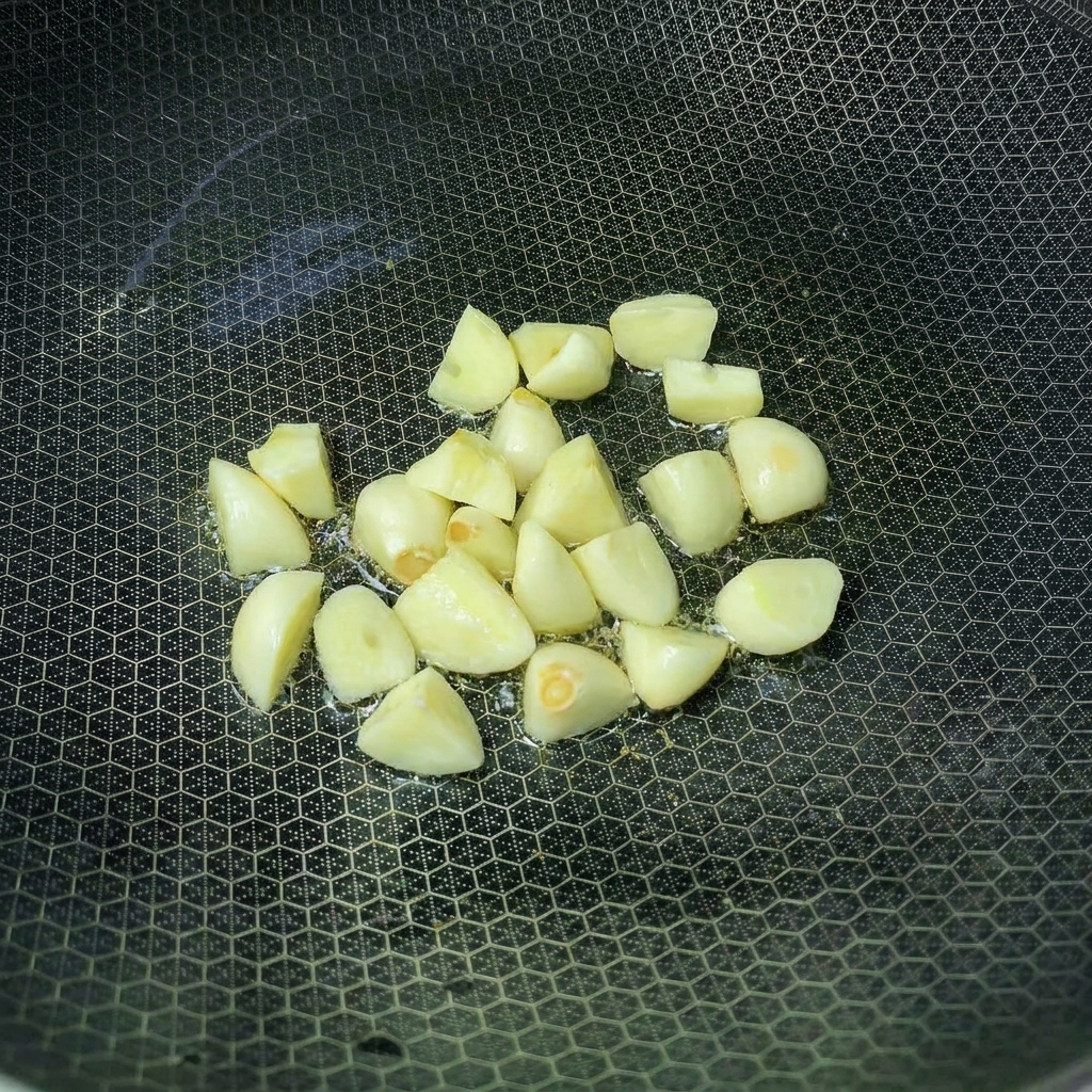 Gousses dail sautant dans un wok avec de lhuile chaude.