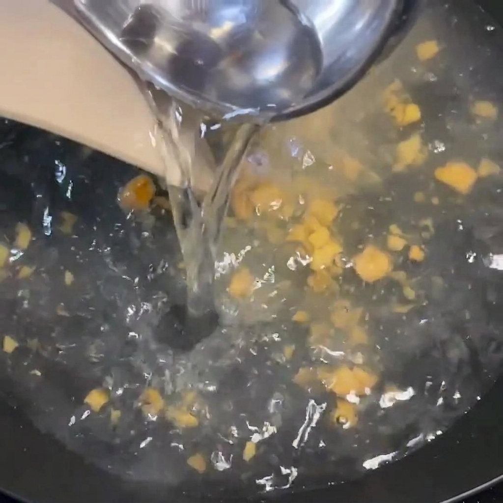 De leau chaude versée à laide dune louche dans une casserole frémissante contenant lassaisonnement.