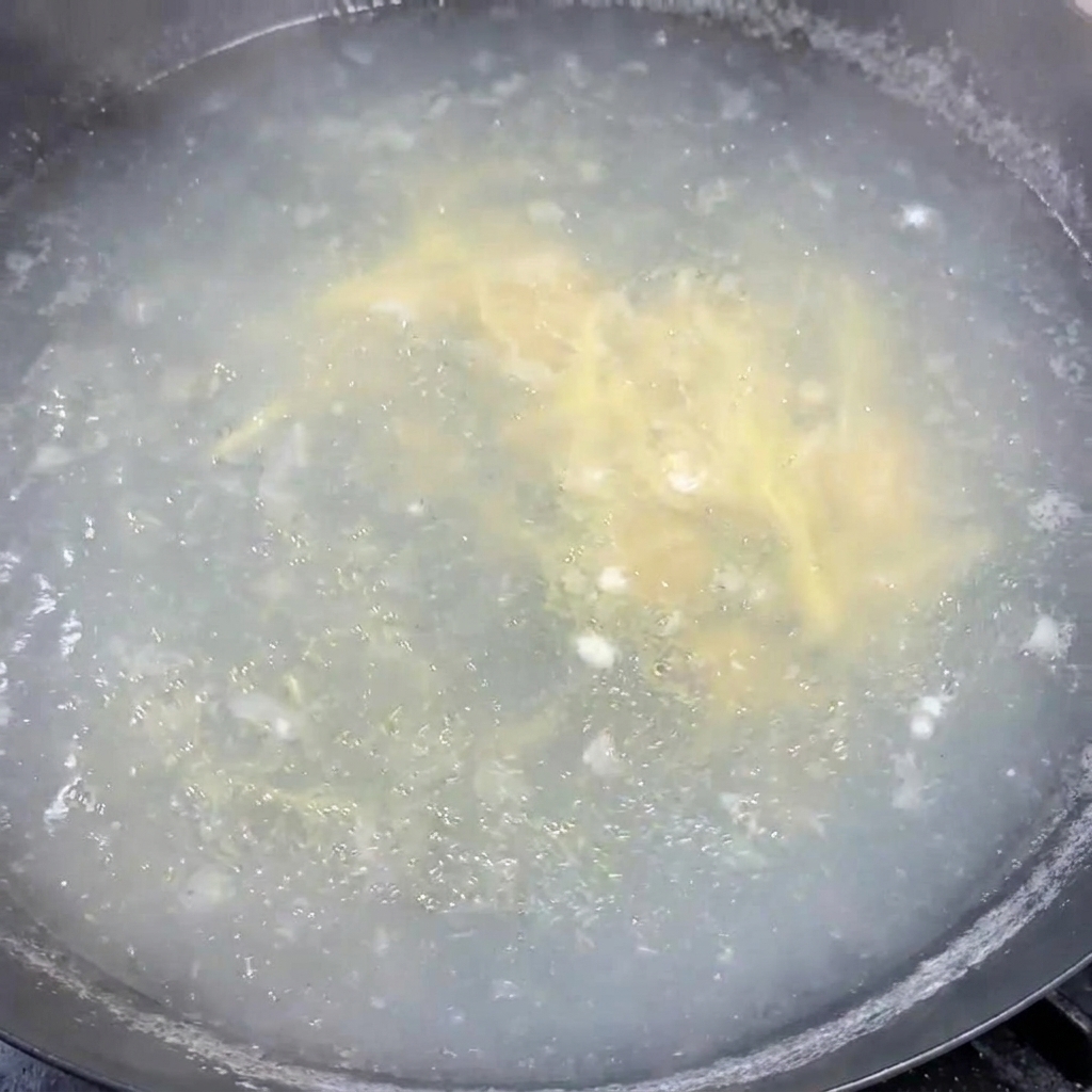 Des oignons verts fraîchement ciselés parsemés et mélangés dans la soupe chaude.