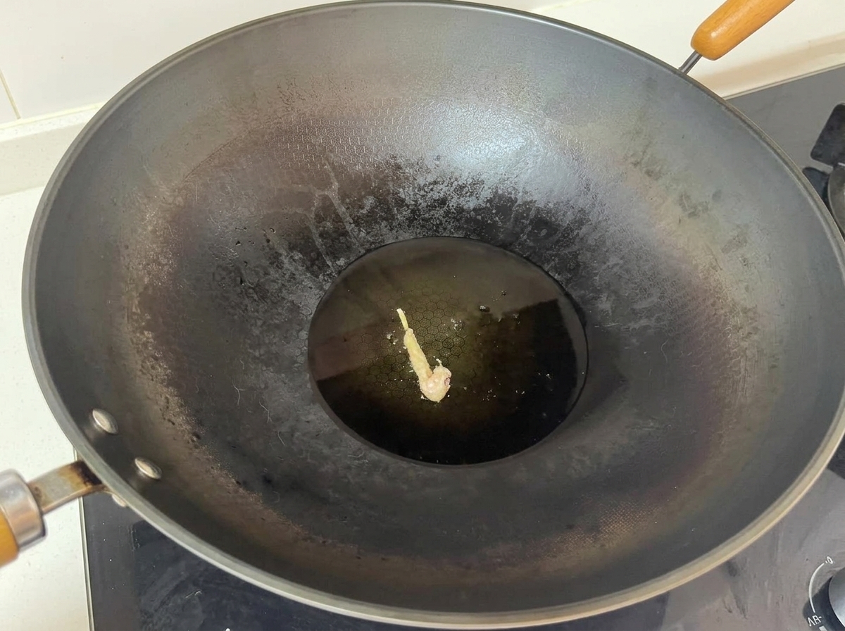 Un unique morceau de poulet enrobé en train de frire au centre dun grand wok rempli dhuile chaude.