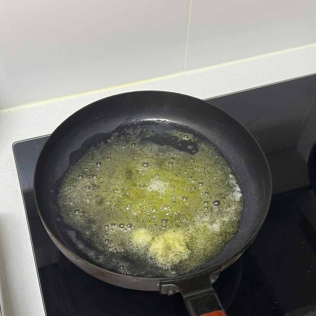 De lail haché cuisant dans du beurre fondu à lintérieur dune poêle.