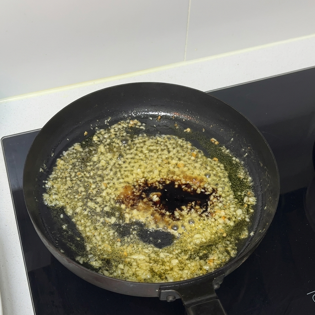 De la sauce huître incorporée au mélange de sauce dans une poêle.