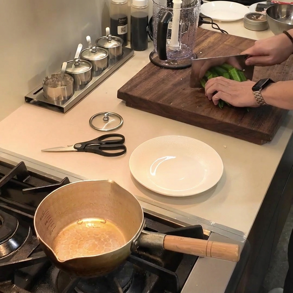 Découpe de gombos verts frais en petits morceaux sur une planche à découper en bois à laide dun grand couteau.