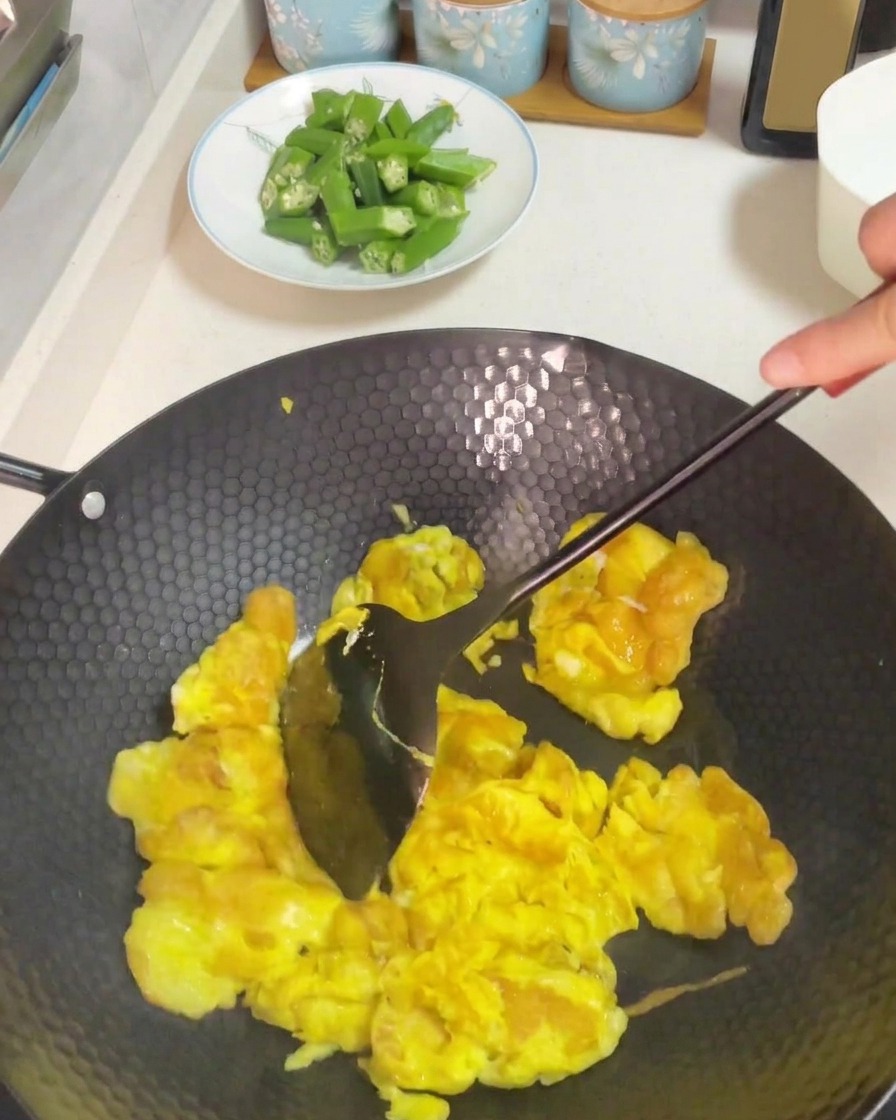 Utilisation dune spatule foncée pour remuer et brouiller les œufs cuits dans un wok chaud.