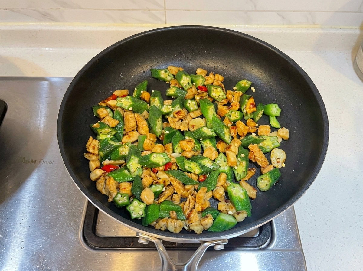 De la sauce huître ajoutée au wok de poulet et de gombos.
