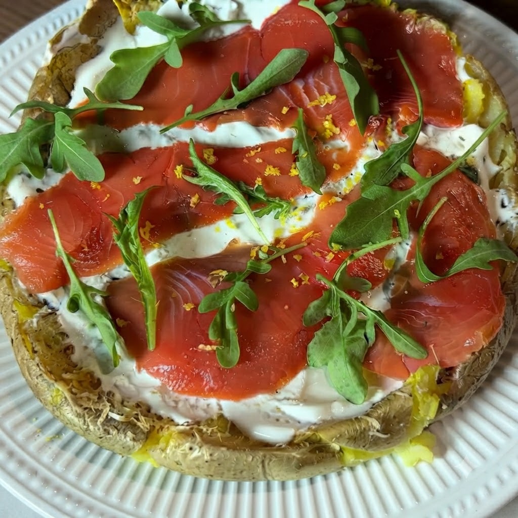 Une vue rapprochée de zeste de citron jaune fraîchement râpé saupoudré sur la pizza de pommes de terre garnie.