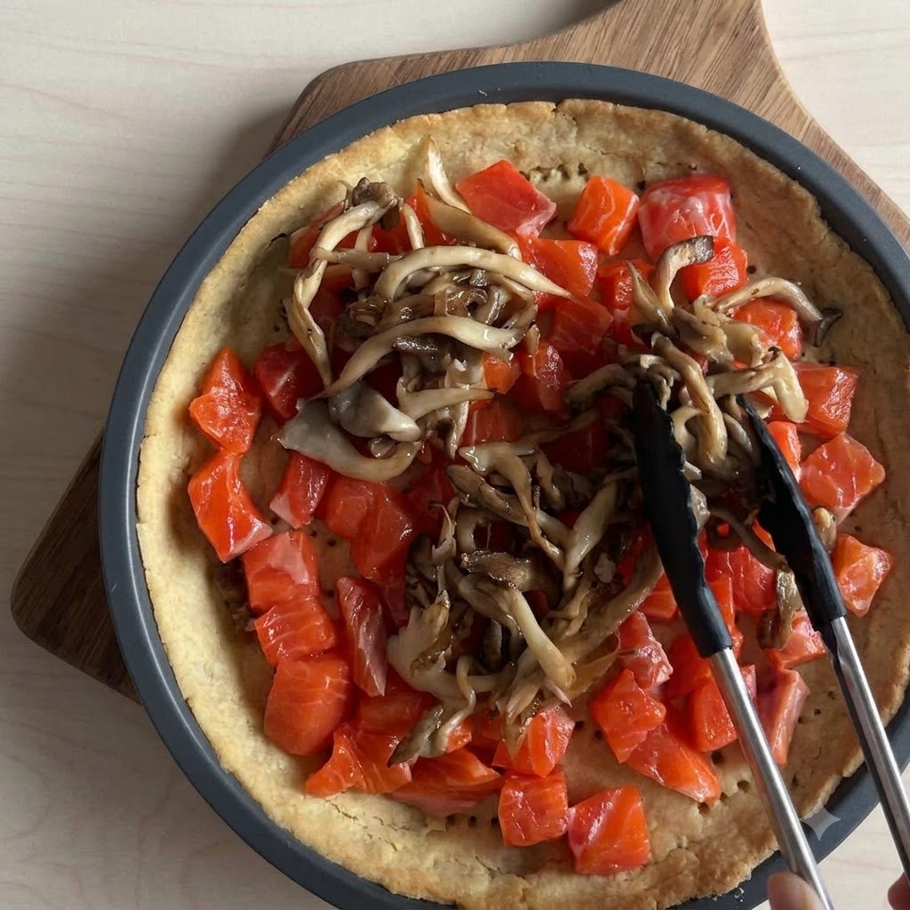 Des morceaux de mozzarella fraîche émiettés à la main sur la garniture de saumon et de champignons.