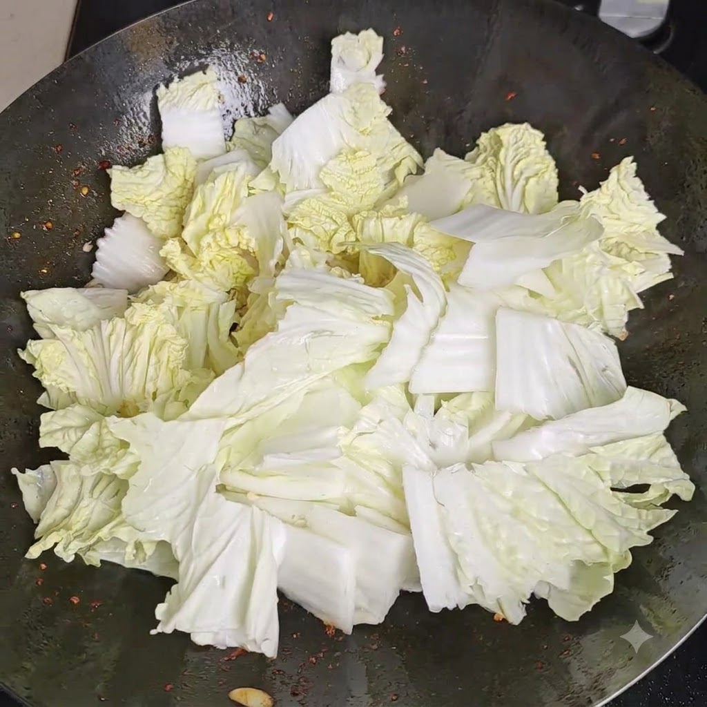 Du sel saupoudré uniformément sur un monticule de morceaux de chou chinois frais à lintérieur dun wok.