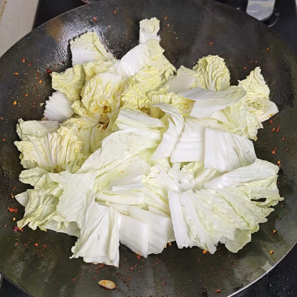 Du vinaigre versé le long du périmètre chauffé du wok, réagissant avec la surface chaude.