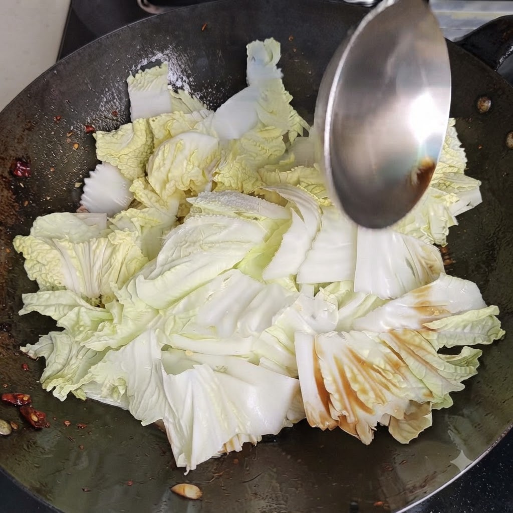 Une spatule de wok en métal mélangeant et remuant vigoureusement du chou chinois et des assaisonnements à lintérieur dun wok chaud.
