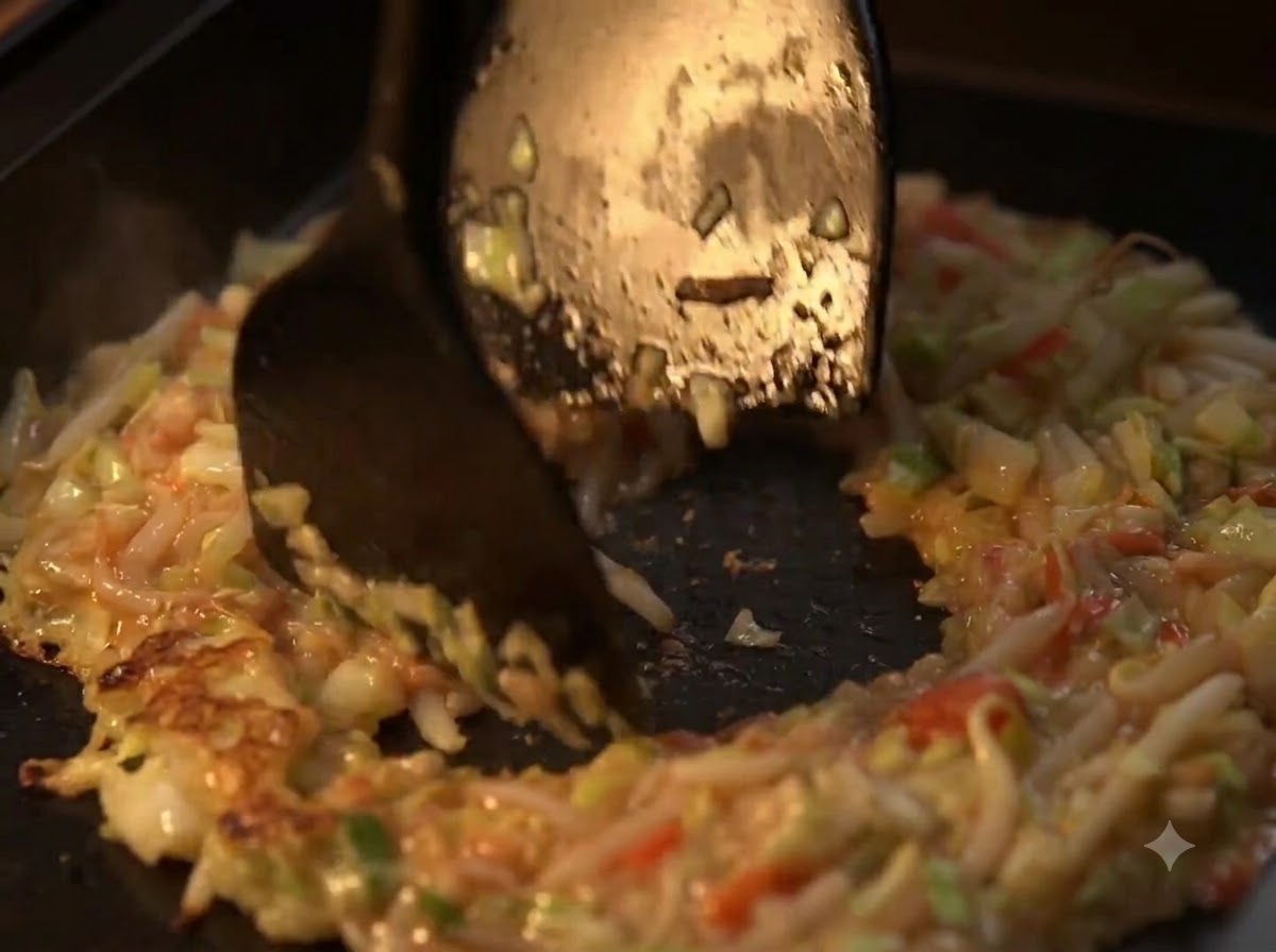 Des spatules façonnant le mélange de légumes sautés en anneau avec un centre creux sur une plaque chauffante.