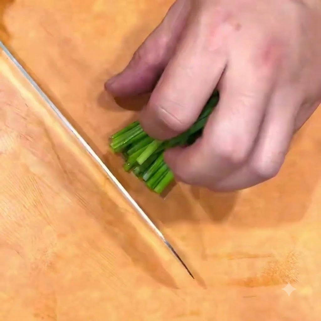 Oignons verts coupés en fleur de ciboule sur une planche en bois avec un couteau.