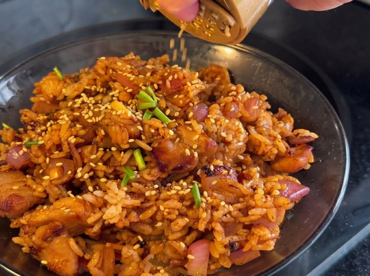 Du kimchi ajouté dans la poêle et sauté avec le poulet et les oignons.