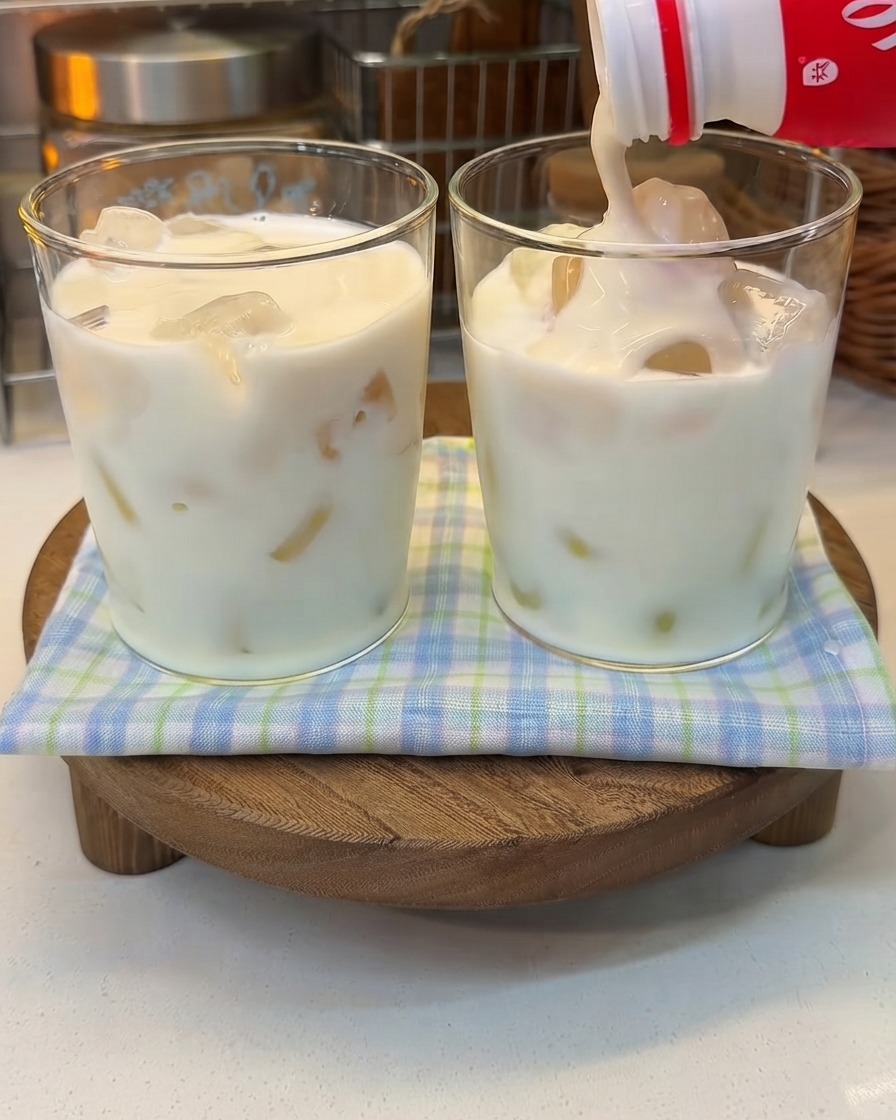 Du yaourt épais versé dune bouteille dans un verre de lait glacé.