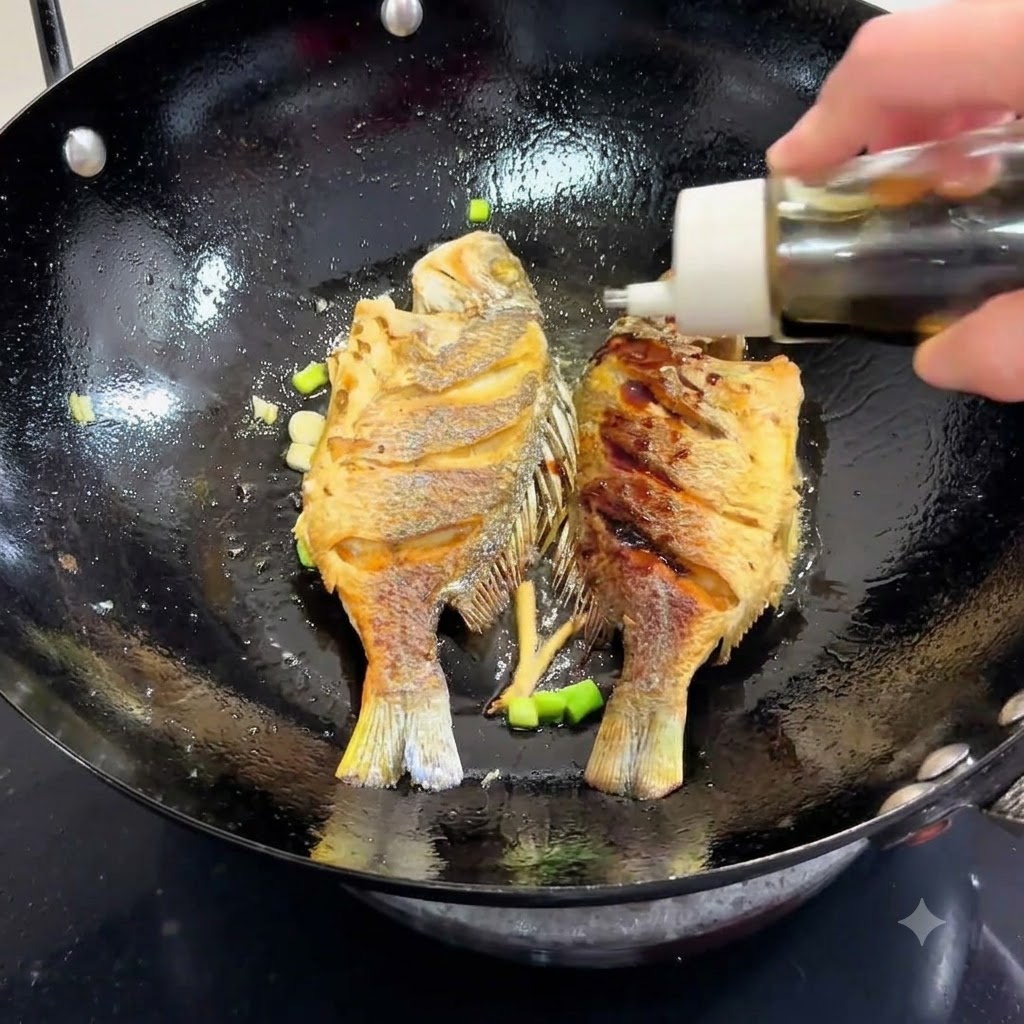 De la sauce soja versée dune bouteille dans un wok contenant du poisson poêlé et des ciboules.