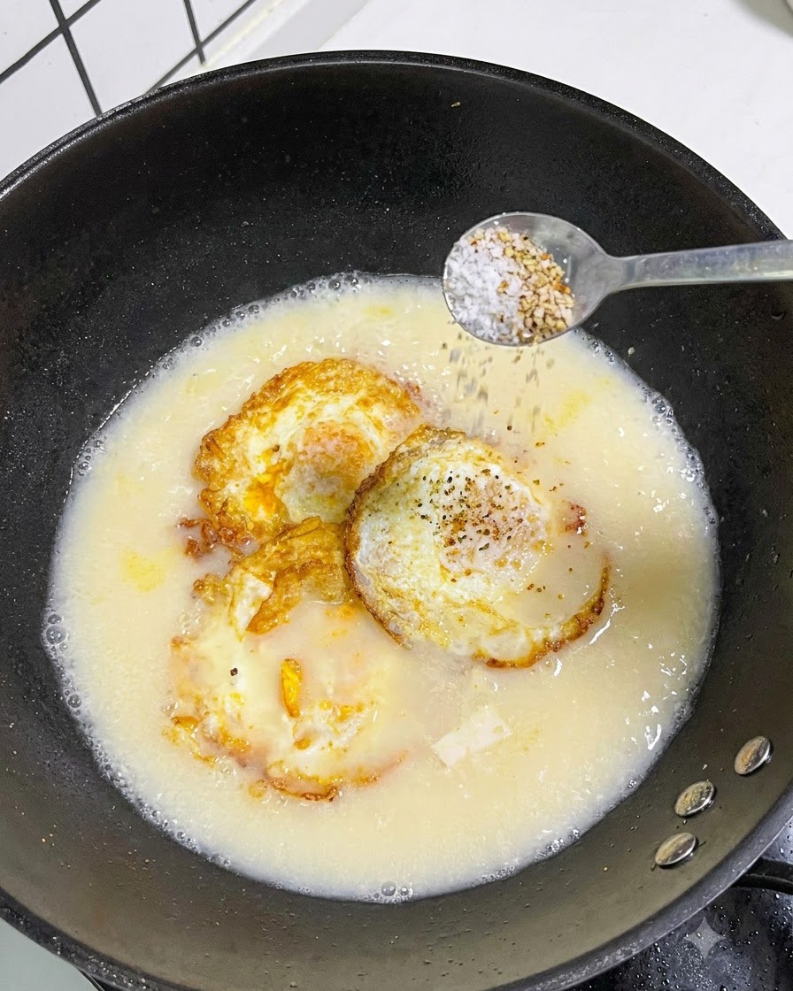 Une cuillerée de sel et de poivre blanc saupoudrée dune cuillère dans une casserole de soupe.
