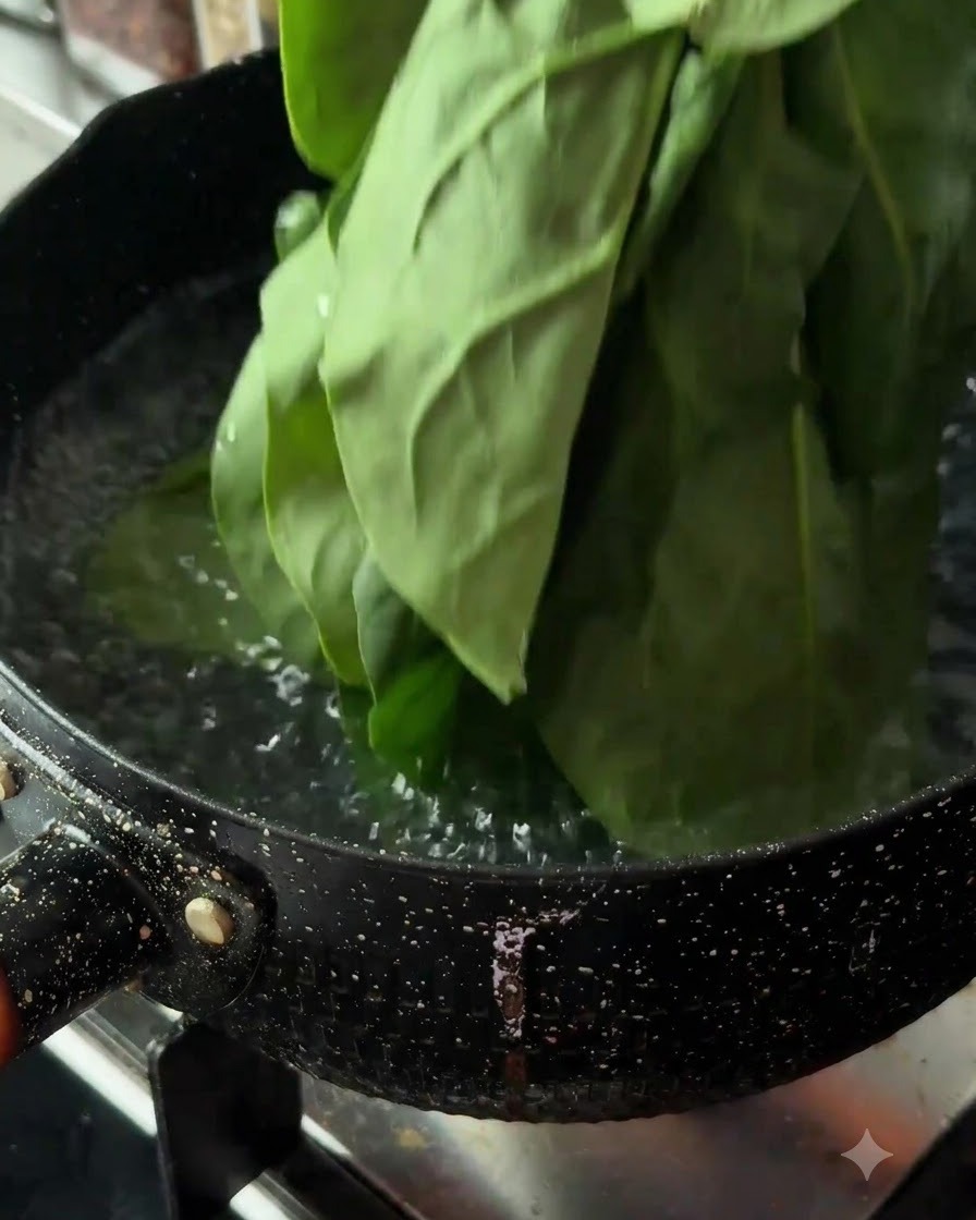Feuilles dépinards frais plongées dans une casserole deau bouillante sur une cuisinière.
