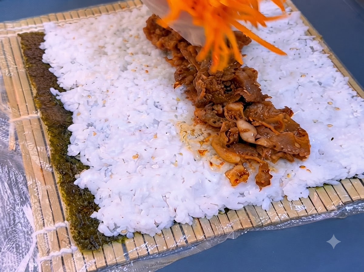 Des carottes râpées déposées sur une lanière de bœuf grillé assaisonné au-dessus du riz blanc.