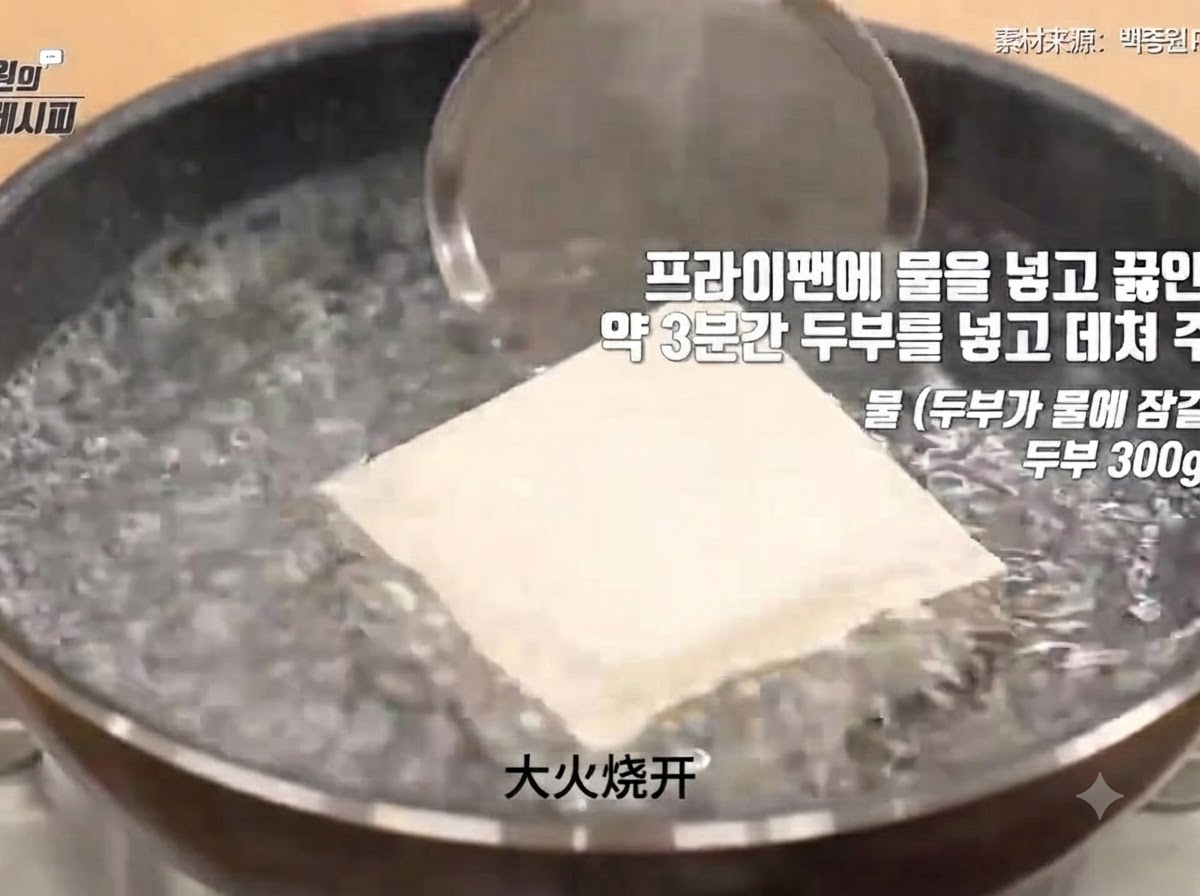 Un bloc de tofu ferme immergé dans une casserole deau bouillante pendant le processus de blanchiment.