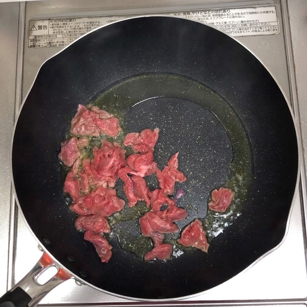 Tranches de bœuf grésillant et brunissant dans une poêle chaude huilée.