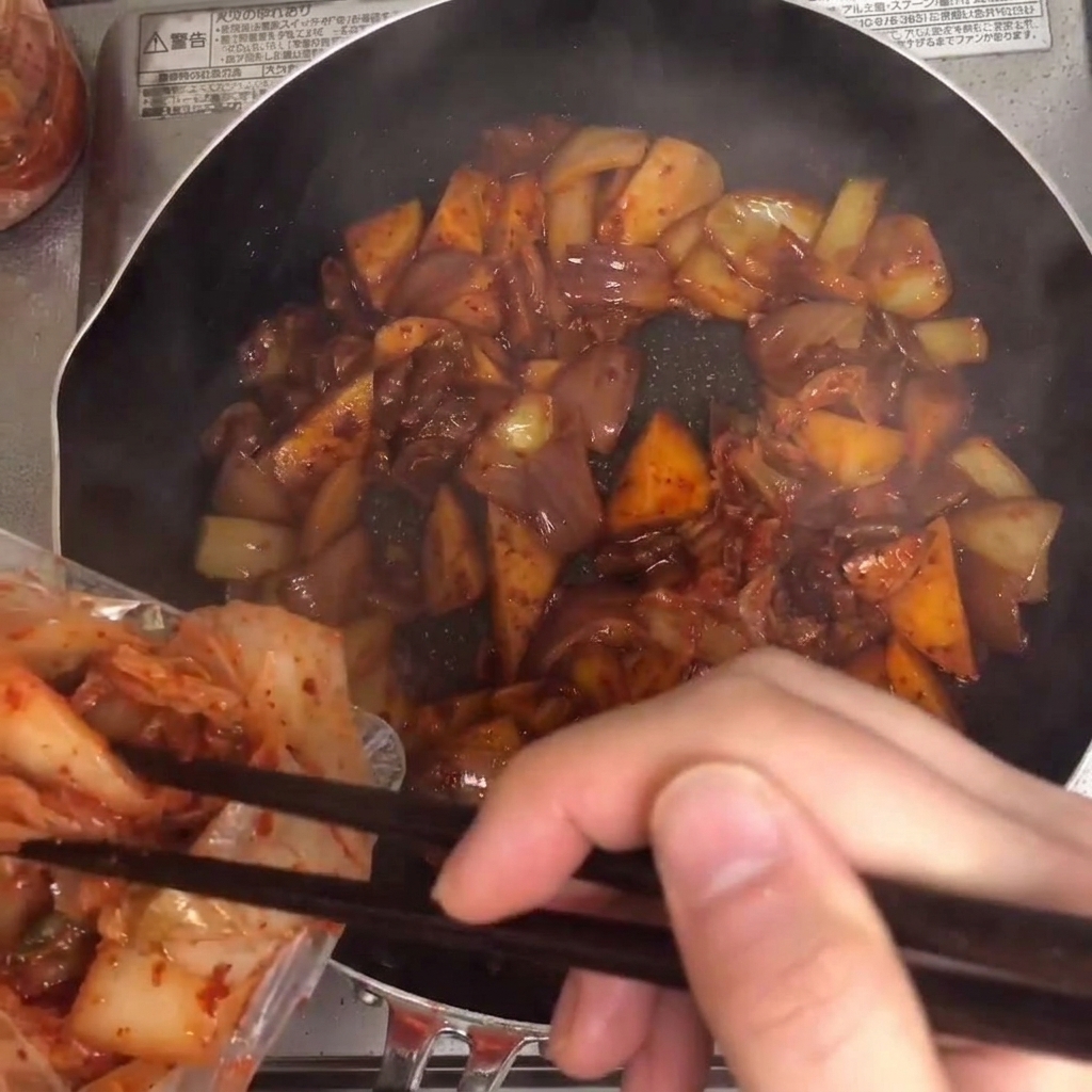 Kimchi ajouté dans la poêle et mélangé avec les autres ingrédients.