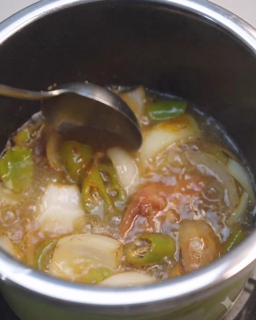 Une cuillère remuant du liquide et de la pâte de soja à lintérieur dune marmite avec des légumes.