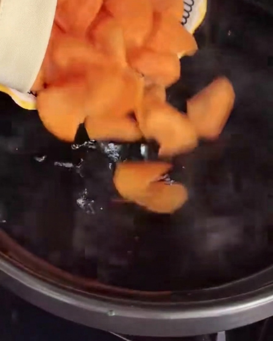 Des rondelles de carottes versées dans une casserole deau bouillante.