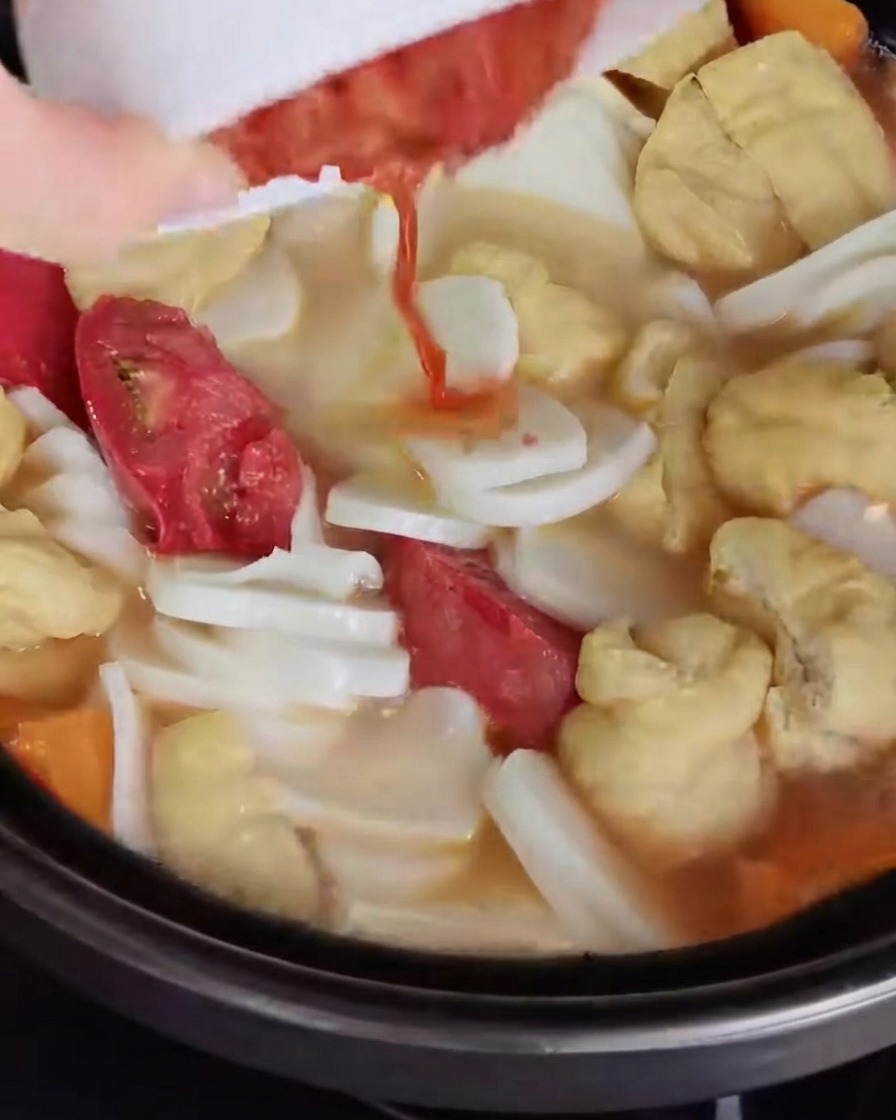 Le kimchi haché versé et mélangé au bouillon.