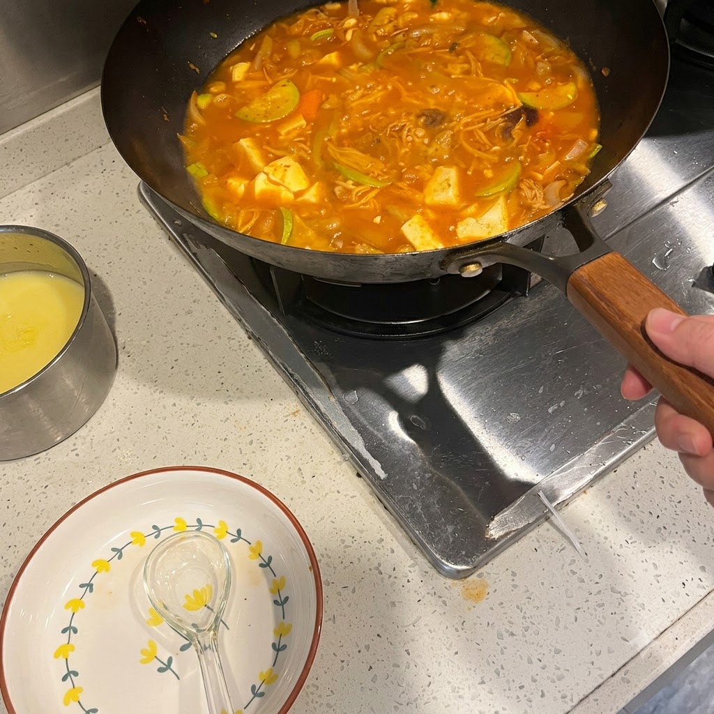 Pâte de piment coréenne mélangée dans une casserole de soupe épicée frémissante avec des légumes et de la viande.