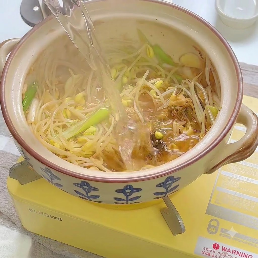 Eau versée dans le pot en céramique sur le mélange de légumes sautés.