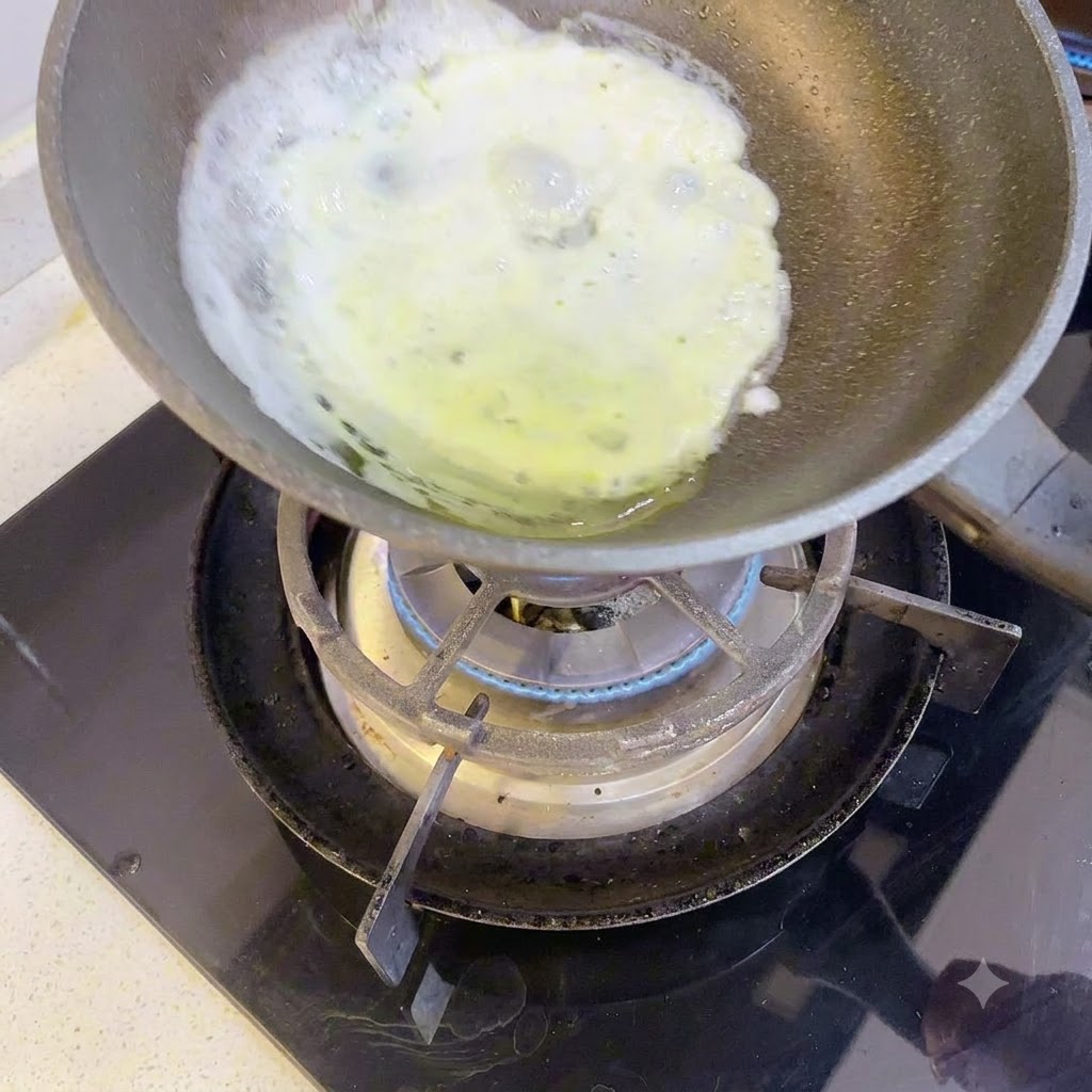 Une fine couche de blanc dœuf cuisant dans une petite poêle sur un brûleur à gaz.