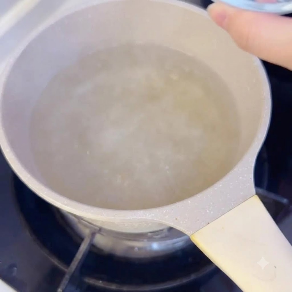 Gâteaux de riz tranchés en train dêtre versés dans une casserole de bouillon bouillant sur la cuisinière.